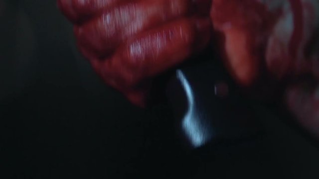 Bloody hand holding knife, slayer trembling with anger, shocked and scared
