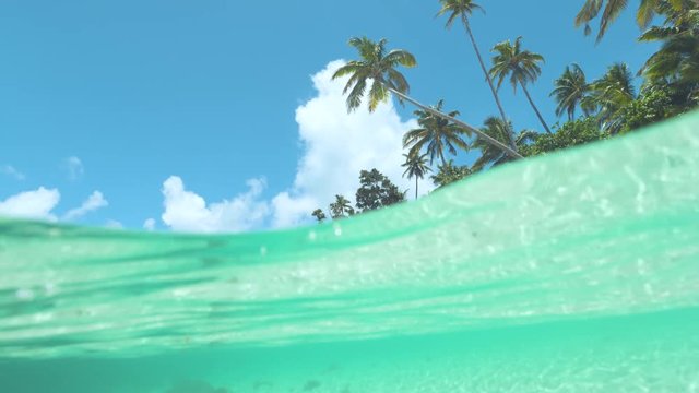 SLOW MOTION, HALF-HALF: Picturesque shot of idyllic sandy beach being washed by emerald water. Empty white sand beach is being swept by stunning turquoise ocean waves. Idyllic holiday destination.