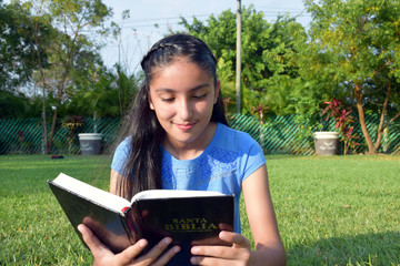 happy girl reading bible outdoors