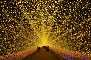 People walking under light tunnel