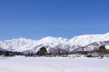 Fototapeta na wymiar 雪景色の白馬村と北アルプス
