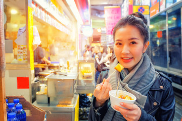 Chinese Asian young female model eating Chinese Steamed Dumpling Street Food in Hong Kong