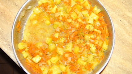 Zucchini stewed with carrots and onions in a pan.