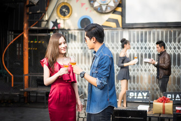 Young couple hand holding whiskey in party.