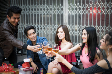 Young people with glasses of whiskey at night party.