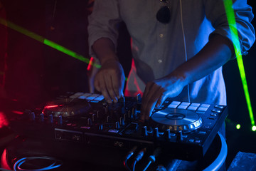 Naklejka premium DJ playing turntable music on night club party