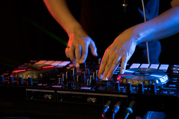 DJ playing turntable music on night club party