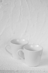 Fototapeta na wymiar tableware mockup. Minimalist cup Mockup. Two white cups on a white relief background. cup on white background. copy space