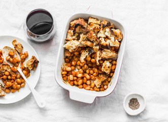 British baked tomato sauce bean and bacon with bread crumbs and glass of red vine on light background, top view. Flat lay