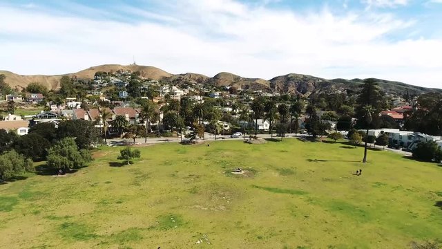 Drone Flyover - Neighborhood park flying towards houses and palm trees