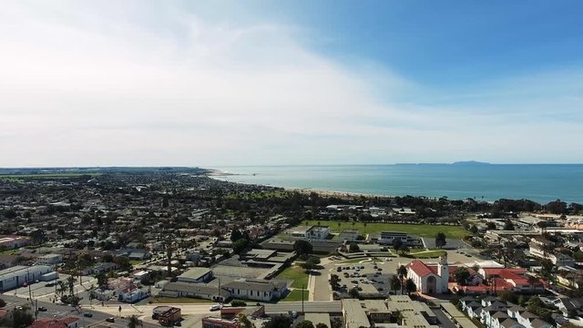 Drone Flyover - Descending view over Ventura, California beach town with Channel Islands National Park in background