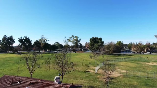 Aerial Shot - Community park rising upward with neighborhood in background