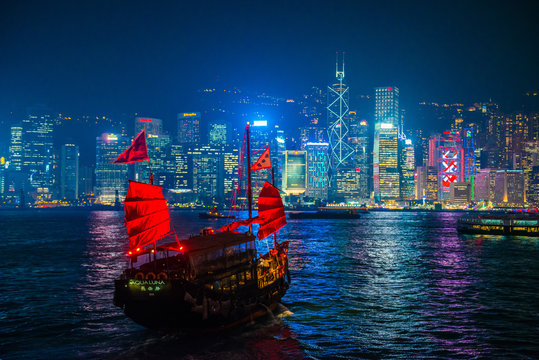 Chinese wooden sailing ship with red sails in Victoria harbor at Hong Kong Island