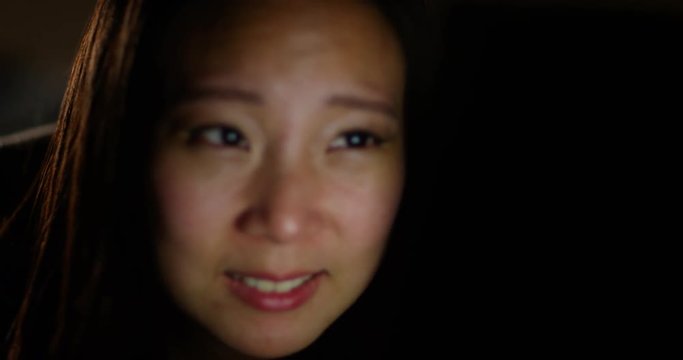 4K Close up on reactions of young woman watching gory or violent movie late at night
