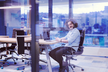 Young casual businessman using smartphone