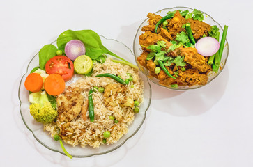 Indian cuisine meal dishes of veg fried rice and spicy chicken kosha with salad isolated on white background.