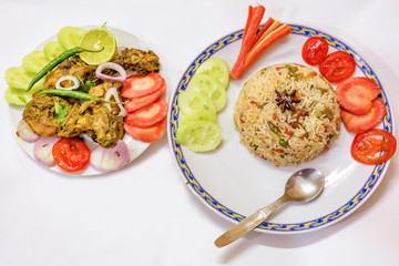 Indian meal of vegetable fried rice with dry spicy chicken curry served with salad