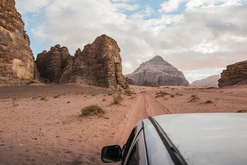 The view from the body of the jeep on beautiful views of sand and large rocks in the Wadi rum desert in Jordan on a evening