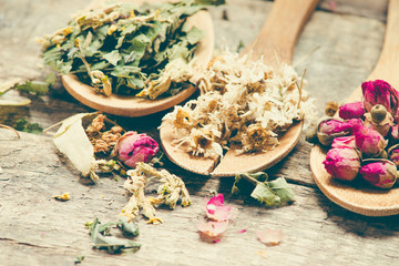 Aromatic flower tea in spoon on rustic wooden background/toned photo