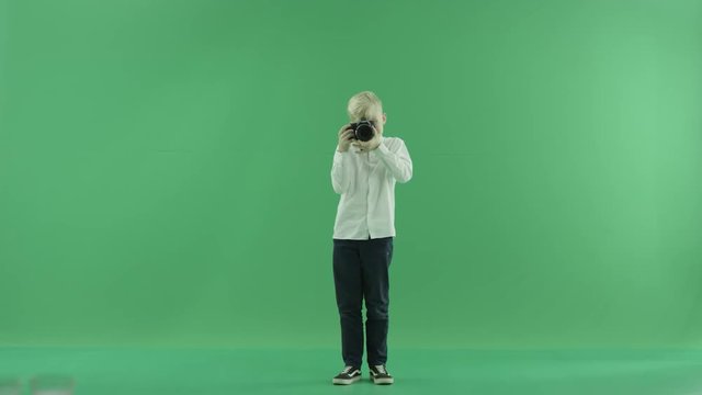 The child is taking photos of a viewer on the green screen and makes some corrections