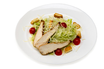 Caesar salad with chicken in a plate on a white background