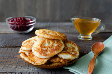 Russian-style fritters on dark wooden background