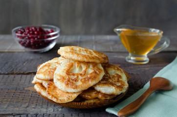 Russian-style fritters on dark wooden background