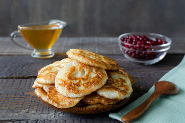 Russian-style fritters on dark wooden background