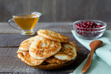 Russian-style fritters on dark wooden background