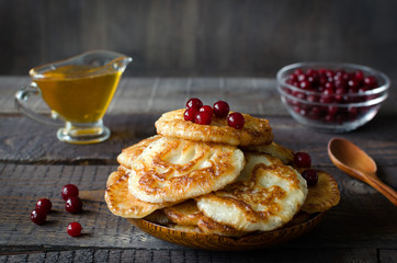 Russian-style fritters on dark wooden background