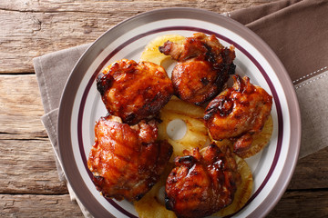 Hawaiian grill spicy chicken thighs huli huli with pineapple closeup on a plate. Horizontal top view from above