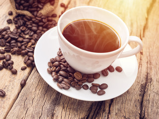 hot coffee cup with coffee bean on wooden table. coffee background for cafe or coffee shop