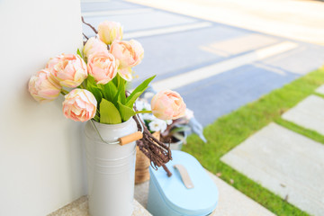 beautiful pink artificial flowers in white vase on a floor.