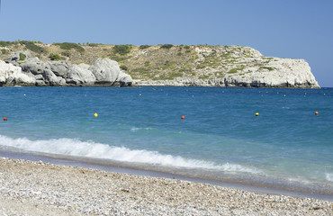 Seascape with a coastline of the Mediterranean sea, the mountain and the colorful buoys on the water