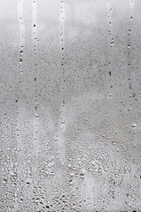 Texture of a drop of rain on a glass wet transparent background. Toned in grey color