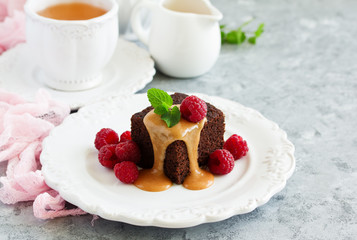 Sticky pudding with caramel sauce and fresh raspberries.