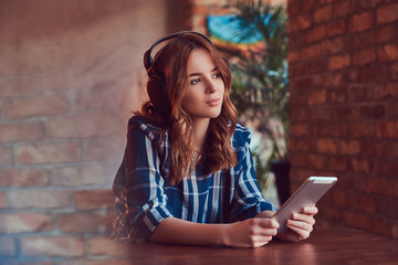 A young charming sensual girl listening to a music in headphones