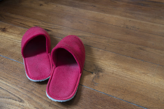a pair of red slippers on the wooden floor