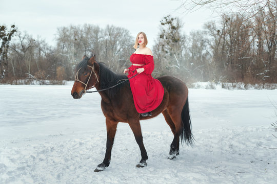 Blonde woman riding a horse.