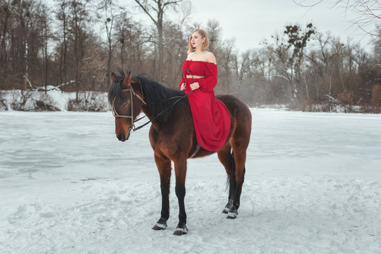 Young blonde woman riding a horse.