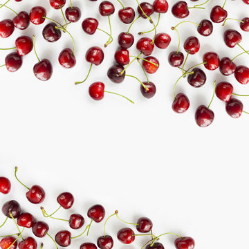 Fresh red cherries lay on white isolated background with copy space for text. Background of cherries. Top view. Cherry fruit.
