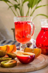 A traditional Scandinavian drink with cranberries and berries in a glass and jug