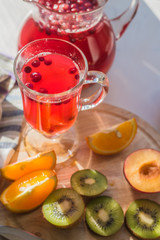 A traditional Scandinavian drink with cranberries and berries in a glass and jug