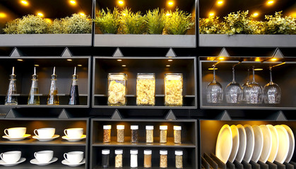 Close-up of kitchen shelves with dishes, lighting and floral decor in a beautiful modern kitchen interior