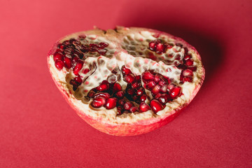 Pomegranate on red background close up