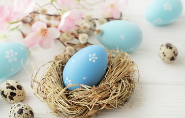 Fototapeta na wymiar easter eggs and flowers on white wooden background