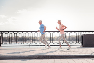 Dont lag behind. Senior sporting persistent couple having common training spending time on fresh...