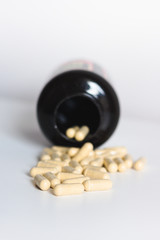 Pills capsules with bottle on white background