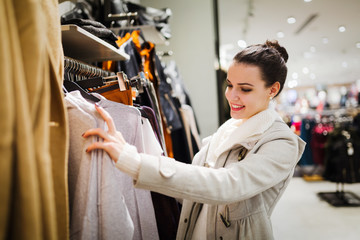 Young attractive woman buying clothes in mall