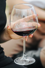 Woman drinking alcohol. Close-up shot of glass of wine in a hand.